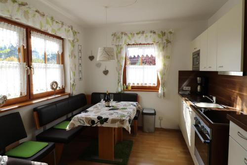 eine kleine Küche mit einem Tisch und einem Sofa in einem Zimmer in der Unterkunft Ferienwohnung Leibelt in Füssen