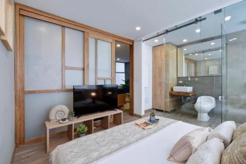 um quarto com uma cama, uma televisão e uma casa de banho em Studio Bogota middle of it ! em Bogotá