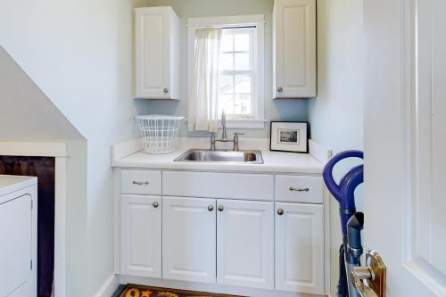 a kitchen with white cabinets and a sink at The Ranch in Duck