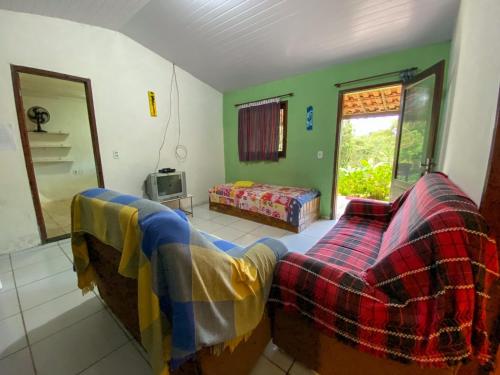 een woonkamer met 2 bedden en een raam bij Casa no Sítio in Guaramiranga