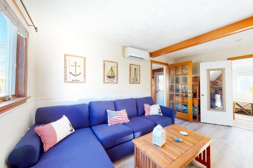 a blue couch in a living room with a table at Swift Beach House in Wareham