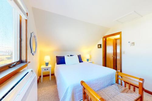 a bedroom with a white bed and a window at Swift Beach House in Wareham