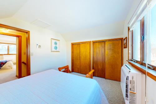 a bedroom with a large bed and a window at Swift Beach House in Wareham