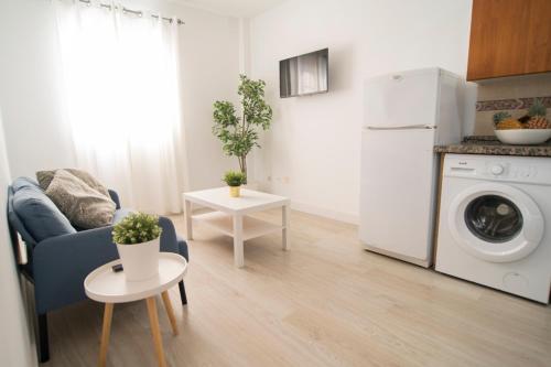 a living room with a washing machine and a table at Alojamientos el Bajón in La Restinga