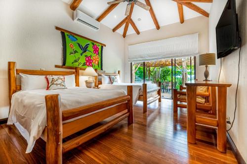 1 dormitorio con 2 camas y TV de pantalla plana en Villa Marbella, en Islita