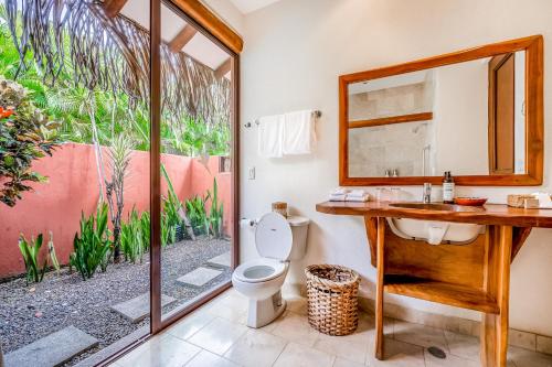 a bathroom with a toilet and a sink and a mirror at Villa Marbella in Islita