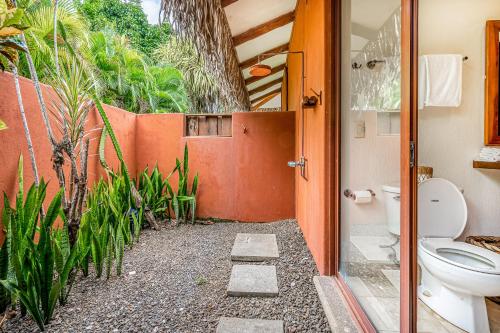 a bathroom with a toilet and some plants at Villa Marbella in Islita