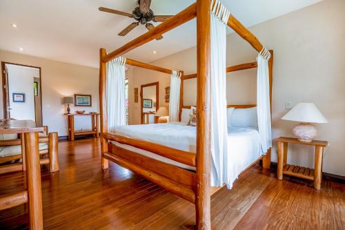 a bedroom with a four poster bed with a ceiling fan at Villa Marbella in Islita