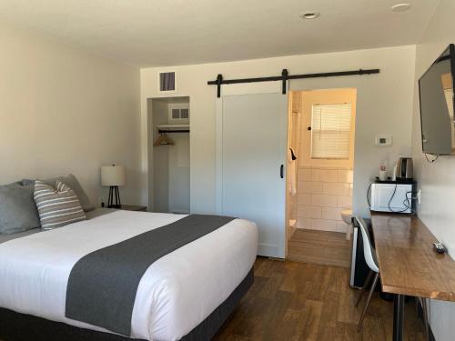 a bedroom with a bed and a desk and a door at City Center Motel in Missoula