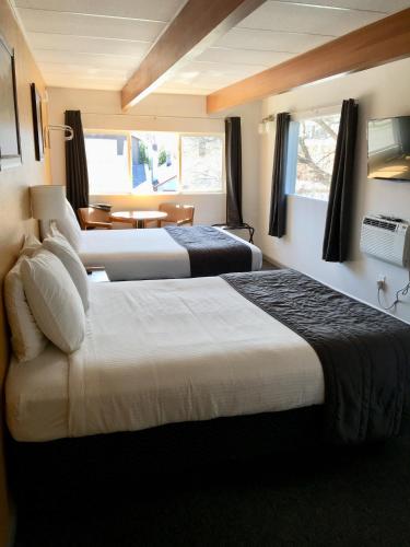 a hotel room with two beds and a table at City Center Motel in Missoula