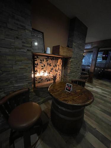 a room with a table and a stone fireplace at The Historic Brookdale Lodge, Santa Cruz Mountains in Brookdale