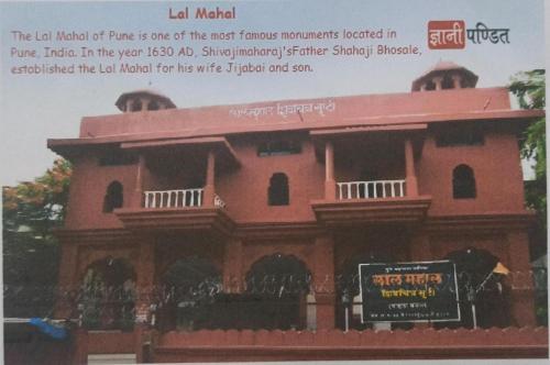 a building with a sign in front of it at Malwade Motel in Pune