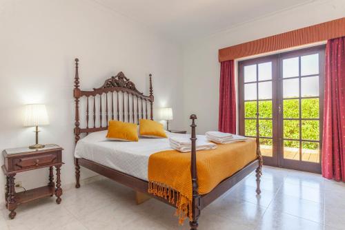 a bedroom with a bed and a large window at G - Vila Céu Guesthouse in Odiáxere