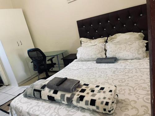 a bed with a black and white blanket and a table at Crystal Mini Pozz Palace in Johannesburg