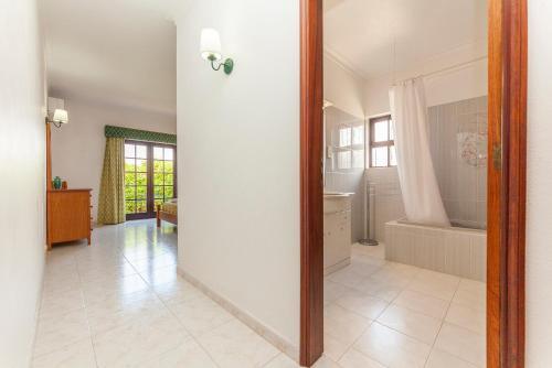 a bathroom with a tub and a sink and a mirror at Vila Céu Guesthouse in Odiáxere