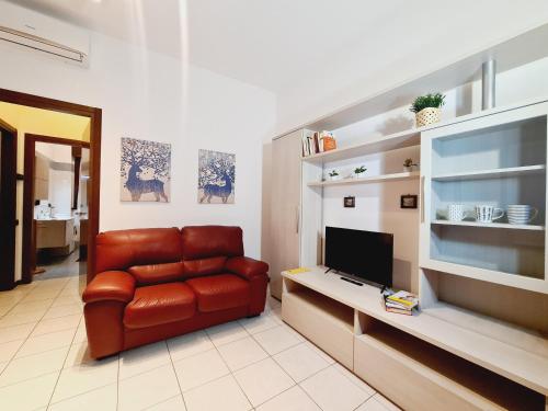 a living room with a leather couch and a television at San Siro House in Milan