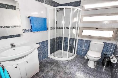 a bathroom with a shower and a toilet and a sink at Villa Golden Coral in Peyia