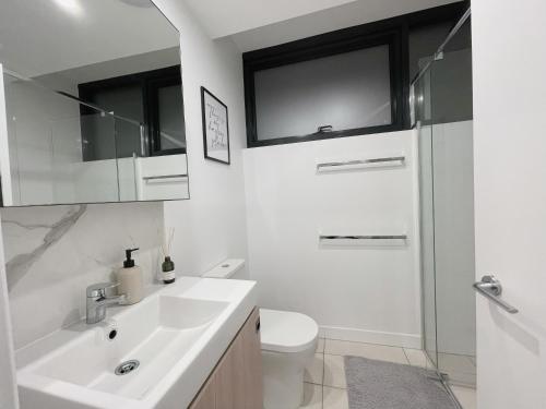 ein weißes Bad mit einem Waschbecken und einem WC in der Unterkunft City Escape House at Cultural Centre Precinct in Brisbane
