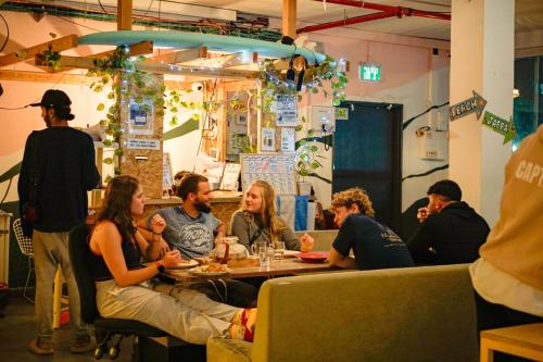 eine Gruppe von Menschen, die in einem Restaurant an einem Tisch sitzen in der Unterkunft Jungle Jaffa Hostel Age 18 to 45 in Tel Aviv