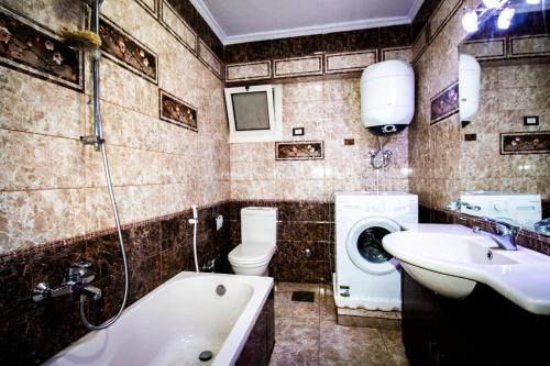 uma casa de banho com um lavatório, um WC e uma banheira em Yellow & brown moderne style Near food-court no Cairo
