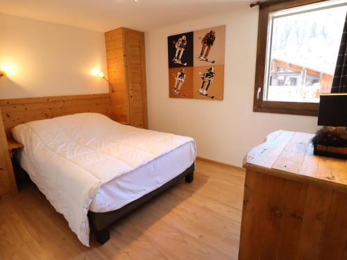 une chambre avec un grand lit et une fenêtre dans l'établissement Appartement Centre Les Gets, Balcon, 4/6 Couchages, Parking Inclus, Proche Remontées Mécaniques - FR-1-623-5, aux Gets