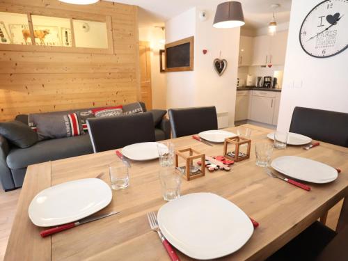 une table en bois avec des plaques blanches au-dessus dans l'établissement Appartement Centre Les Gets, Balcon, 4/6 Couchages, Parking Inclus, Proche Remontées Mécaniques - FR-1-623-5, aux Gets