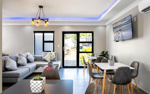 a living room with a couch and tables and chairs at Woman Era Guest House in Midrand