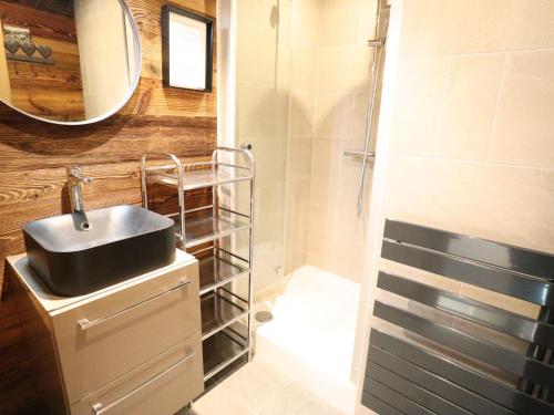 une salle de bain avec un lavabo et une douche avec un miroir dans l'établissement Appartement avec balcon au pied des pistes, Les Gets - FR-1-623-147, aux Gets