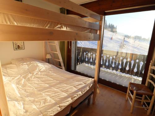 - une chambre avec des lits superposés et un balcon dans l'établissement Appartement avec balcon au pied des pistes, Les Gets - FR-1-623-147, aux Gets