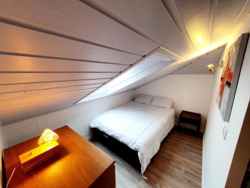 une petite chambre avec un lit et une table dans l'établissement Appartement cosy au vieux village avec parking, proche des pistes et télécabines - FR-1-623-118, aux Gets