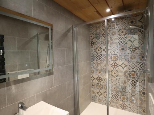 une douche avec une porte vitrée dans une salle de bain dans l'établissement Appartement cosy au vieux village avec parking, proche des pistes et télécabines - FR-1-623-118, aux Gets