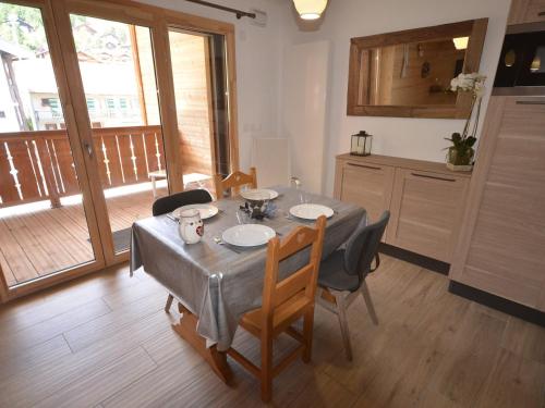 une salle à manger avec une table et des chaises et une cuisine dans l'établissement Appartement Duplex de Standing au Centre - 4 Couchages, Balcon, Garage Privé, WiFi - FR-1-623-204, aux Gets