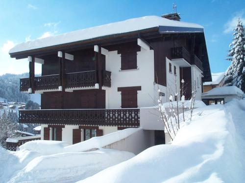 un bâtiment enneigé avec un balcon dans la neige dans l'établissement Studio avec terrasse et garage aux Gets - FR-1-623-221, aux Gets