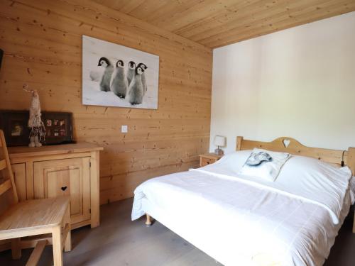 une chambre avec un lit et trois pingouins sur le mur dans l'établissement Les Gets - Charmant 2 pièces au cœur de la station, à 50m des pistes et commerces - FR-1-623-15, aux Gets