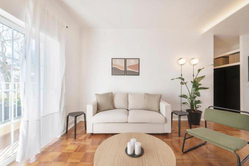 sala de estar con sofá blanco y mesa en Coral Apartment by Olala Homes, en Cascais