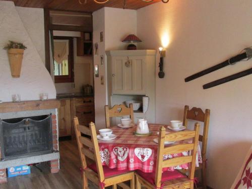 une salle à manger avec une table et des chaises et une cheminée dans l'établissement Appartement cosy, proche des pistes, stationnement, balcon, TV, et équipement cuisine complet - FR-1-623-167, aux Gets