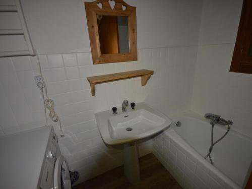 une salle de bain blanche avec un lavabo et une baignoire dans l'établissement Appartement cosy, proche des pistes, stationnement, balcon, TV, et équipement cuisine complet - FR-1-623-167, aux Gets