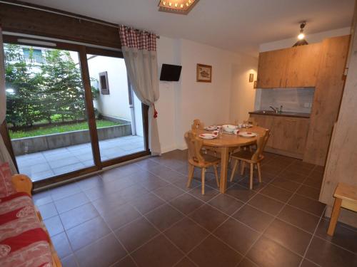 une cuisine et une salle à manger avec une table et des chaises dans l'établissement Appartement au Centre des Gets, Proche Pistes et Commerces, Terrasse et Garage Inclus - FR-1-623-161, aux Gets
