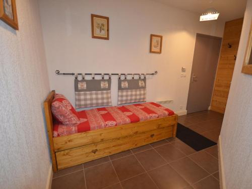 une chambre avec un lit en bois dans une pièce dans l'établissement Appartement au Centre des Gets, Proche Pistes et Commerces, Terrasse et Garage Inclus - FR-1-623-161, aux Gets