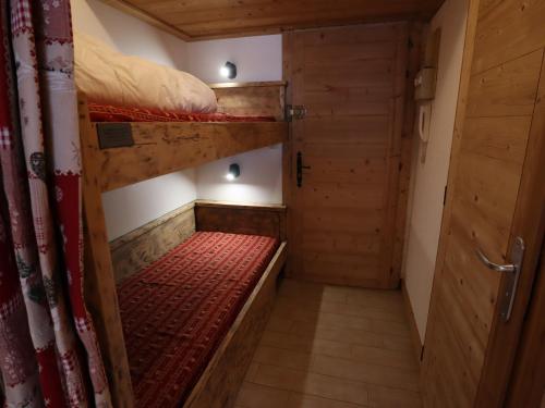 Cette petite chambre comprend 2 lits superposés et une porte. dans l'établissement Studio cosy au cœur des Gets, pied des pistes, refait à neuf, idéal famille! - FR-1-623-53, aux Gets
