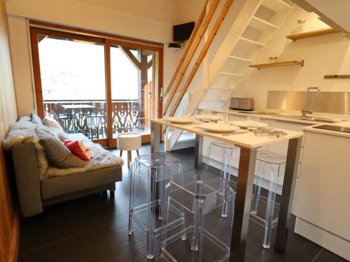une cuisine avec un comptoir avec des tabourets et une table dans l'établissement Appartement rénové aux Gets, proche centre et télécabines, 1 chambre + mezzanine, parking inclus - FR-1-623-54, aux Gets