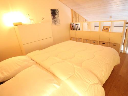 - une chambre avec un grand lit blanc dans l'établissement Appartement rénové aux Gets, proche centre et télécabines, 1 chambre + mezzanine, parking inclus - FR-1-623-54, aux Gets