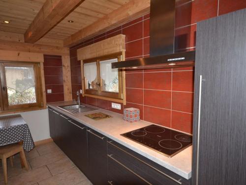 une cuisine avec une cuisinière et un comptoir dans l'établissement Les Gets - Très bel appartement proche du centre - FR-1-623-67, aux Gets