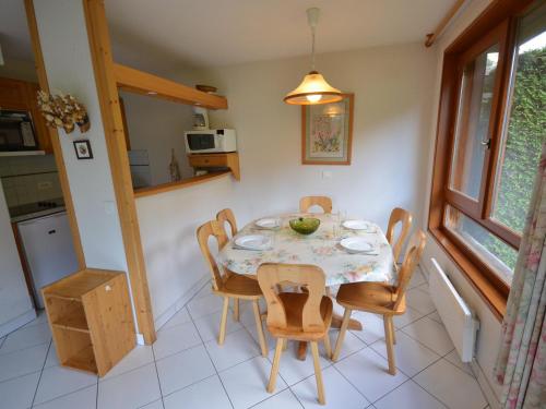 une cuisine et une salle à manger avec une table et des chaises dans l'établissement Appartement 3 étoiles aux Gets, skis aux pieds, balcon, parking et animaux acceptés - FR-1-623-125, aux Gets
