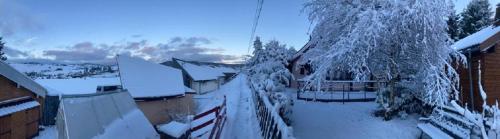 a house covered in snow with a fence at Refuge de l'Ecureuil in Métabief