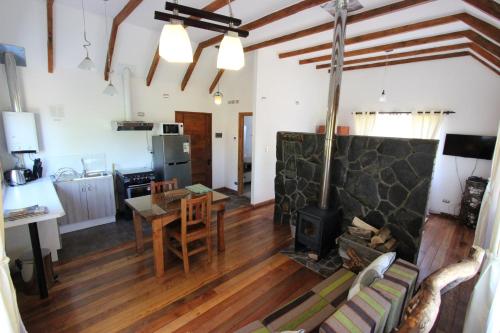 a kitchen and living room with a fireplace and a table at Chile Wild - Las Vertientes in Malalcahuello