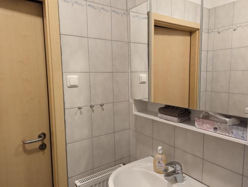 ein Bad mit einem Waschbecken und einem Spiegel in der Unterkunft Restaurant Zur Blume in Hattingen