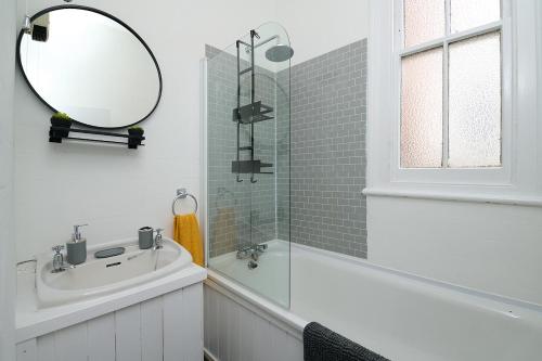 a white bathroom with a sink and a mirror at Spacious 3 Bedroom Apartment- Crouch End in London