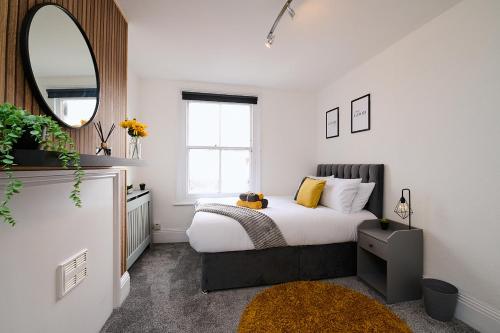 a small bedroom with a bed and a mirror at Spacious 3 Bedroom Apartment- Crouch End in London