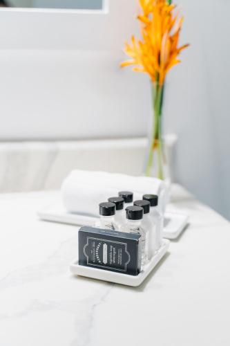 a clock sitting on a table next to a vase with a flower at Blue Roatan Resort in West Bay